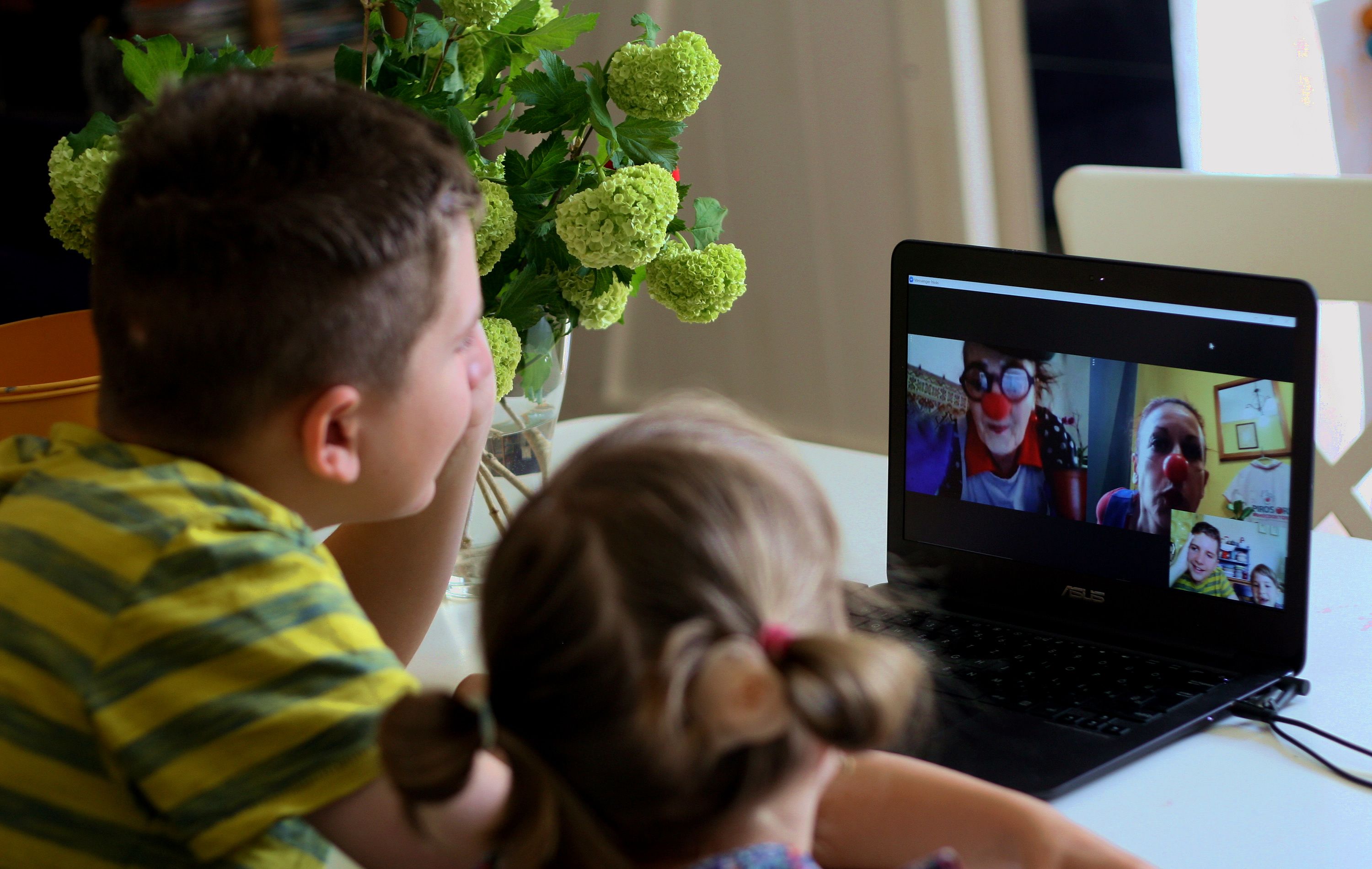 Két kisgyerek laptopon bohócdoktorok műsorát nézi